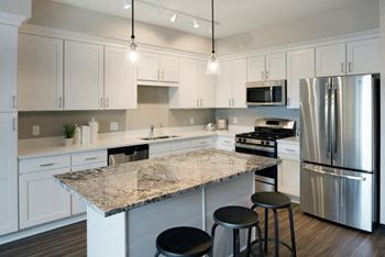 A kitchen with white cabinets and a granite counter top